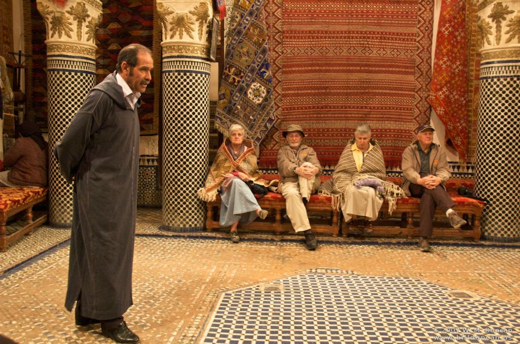 Tourists endure the welcome by rug merchant